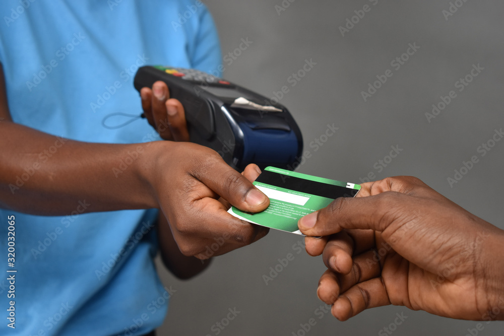 african lady holding a mobile point of sale machine collecting a credit card for someone african lady holding a mobile point of sale machine collecting a credit card for someone