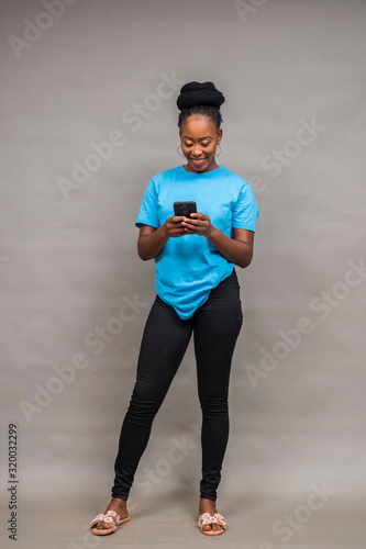 young black woman using her phone standing