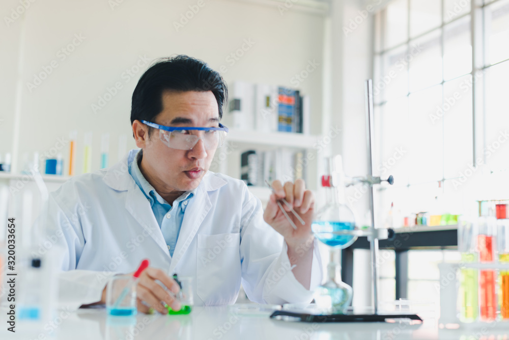 Asian scientists are preparing chemicals for testing and analysis in the laboratory. Scientists clear glasses and white shirts. Science and Chemistry Concept Asian scientists are preparing chemicals for testing and analysis in the laboratory. Scientists clear glasses and white shirts. Science and Chemistry Concept