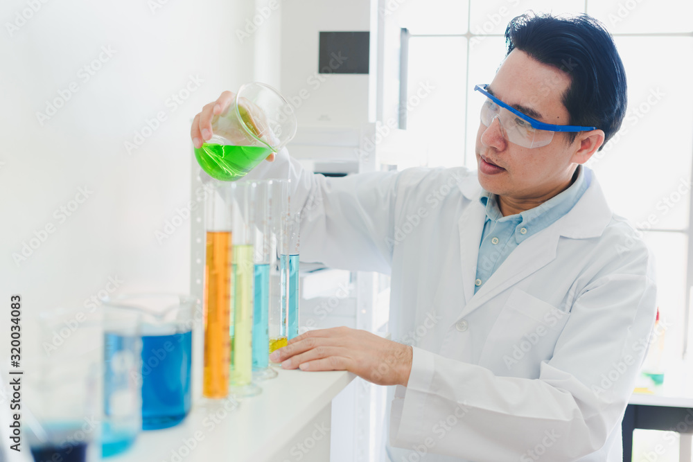 Asian scientists are preparing chemicals for testing and analysis in the laboratory. Scientists clear glasses and white shirts. Science and Chemistry Concept Asian scientists are preparing chemicals for testing and analysis in the laboratory. Scientists clear glasses and white shirts. Science and Chemistry Concept