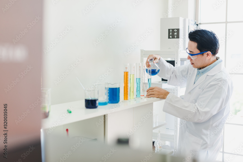 Asian scientists are preparing chemicals for testing and analysis in the laboratory. Scientists clear glasses and white shirts. Science and Chemistry Concept Asian scientists are preparing chemicals for testing and analysis in the laboratory. Scientists clear glasses and white shirts. Science and Chemistry Concept