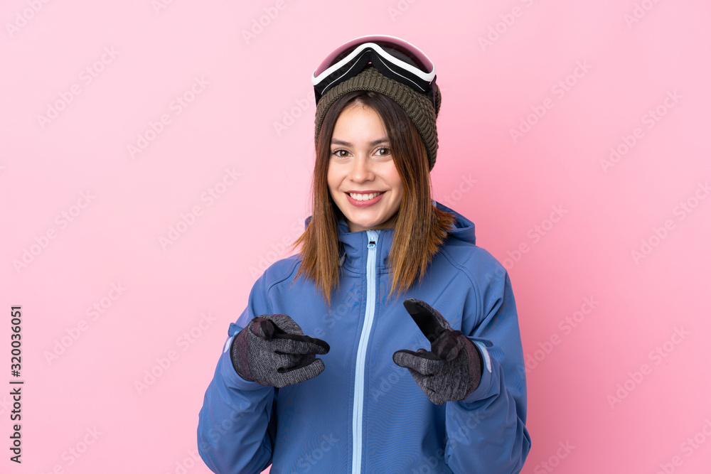Young skier woman over isolated pink background points finger at you Young skier woman over isolated pink background points finger at you
