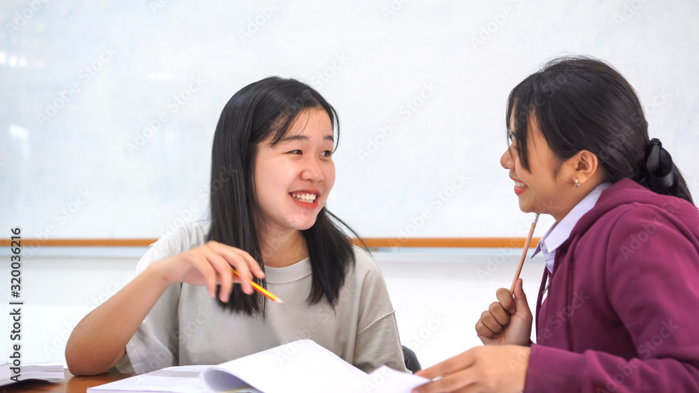 Class in school of Asian students learning homework on table in classroom, front green whiteboard at college in highschool of Asia, Happy in Education study to learn concept Class in school of Asian students learning homework on table in classroom, front green whiteboard at college in highschool of Asia, Happy in Education study to learn concept