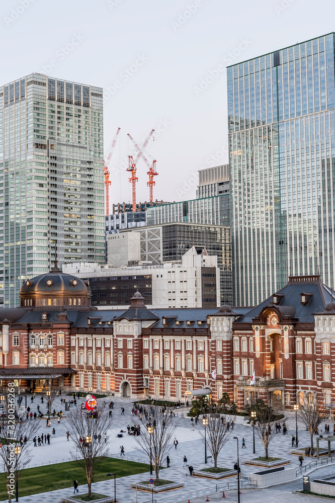 Obraz premium 東京都千代田区丸の内の夕方の東京駅と高層ビル群