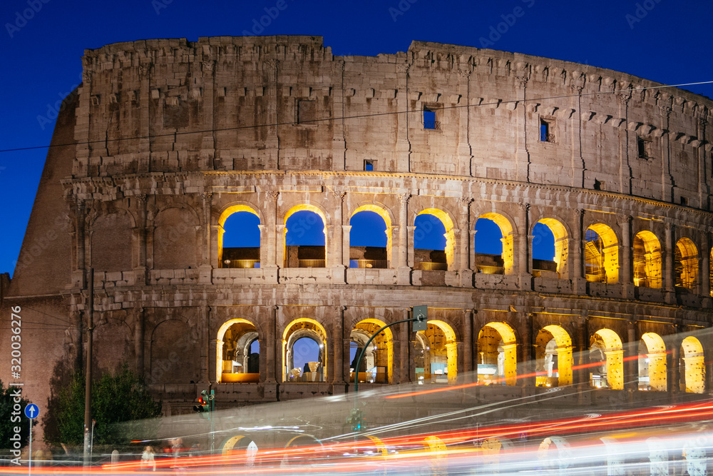 Rome, Italy - Jan 2, 2020: Colosseum at night with colorful blurred traffic lights