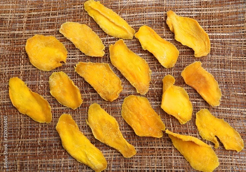 Mango fruit cut into long strips and dried in the sun, yellow lies on the board ready to eat for breakfast.