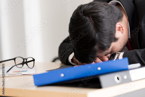 A businessman slept in the working time at the office. photo