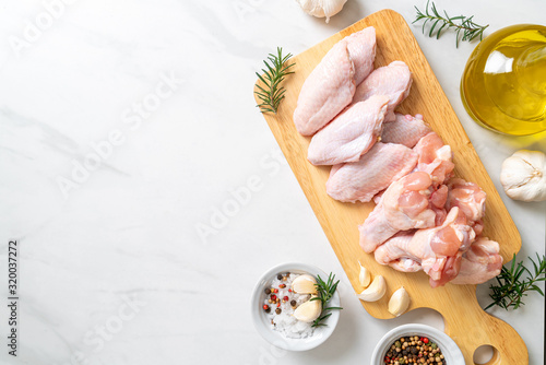 fresh raw chicken wings on wooden board photo