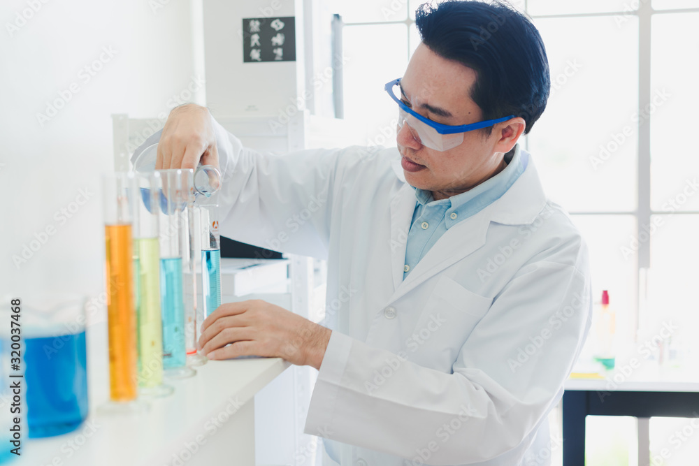 Asian scientists are preparing chemicals for testing and analysis in the laboratory. Scientists clear glasses and white shirts. Science and Chemistry Concept Asian scientists are preparing chemicals for testing and analysis in the laboratory. Scientists clear glasses and white shirts. Science and Chemistry Concept