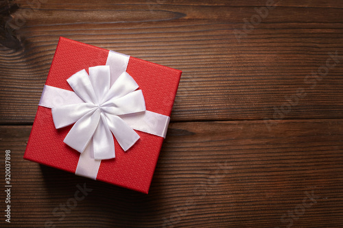 Red gift box on wooden background.
