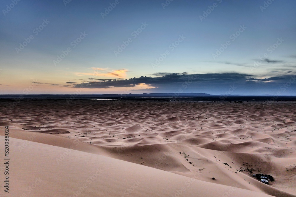 Mystical sand dunes in Sahara with interesting shades and texture in desert landscape during sunset, Morocco, Africa