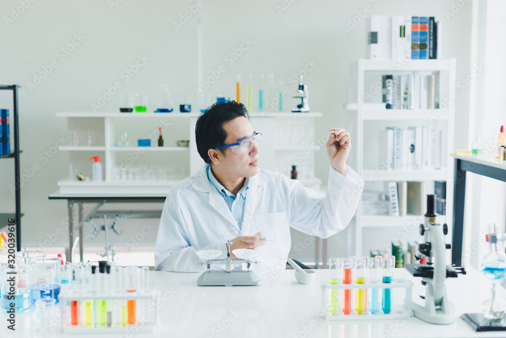 Asian scientists are preparing plant-based materials for testing and analysis in the laboratory. Scientists clear glasses and white shirts. Science and Chemistry Concept Asian scientists are preparing plant-based materials for testing and analysis in the laboratory. Scientists clear glasses and white shirts. Science and Chemistry Concept