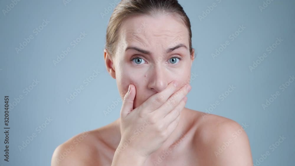Suprised woman covering her mouth and looking at the camera Suprised woman covering her mouth and looking at the camera