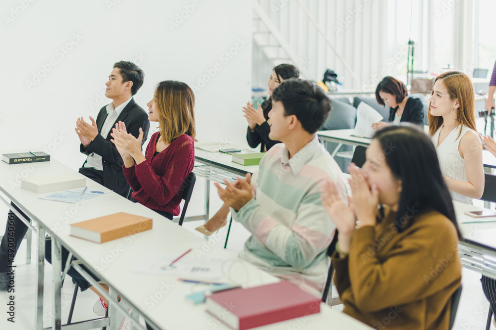 Asians attend seminars and listen to lectures from speakers in the training room.  Some people raised their hands to ask the narrator. And applauded when the speaker finished speaking.