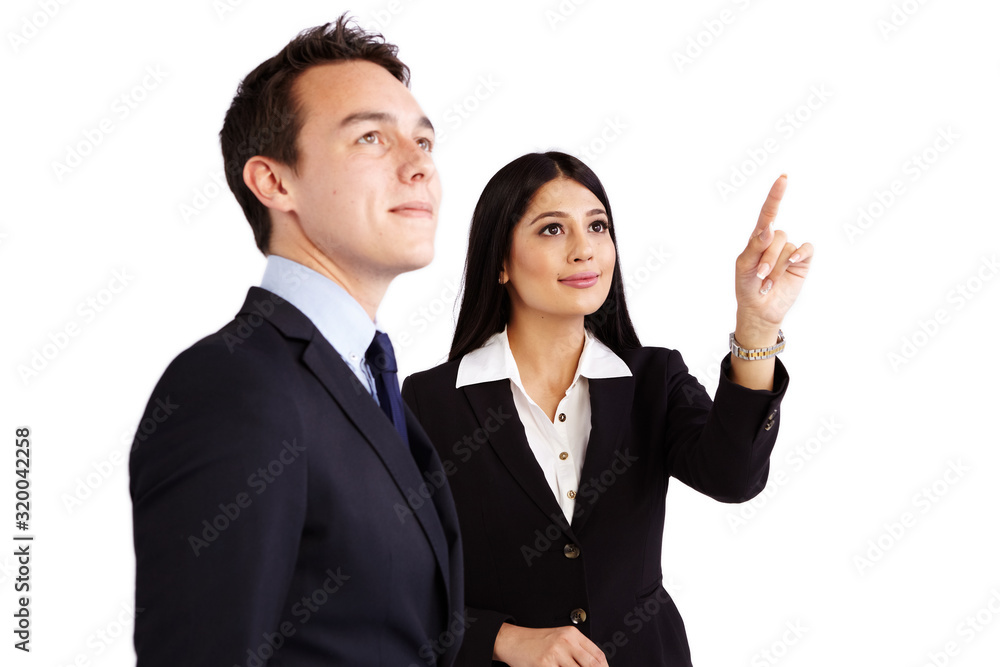 A young business woman is pointing while a young business man is looking up. They are smiling. A young business woman is pointing while a young business man is looking up. They are smiling.