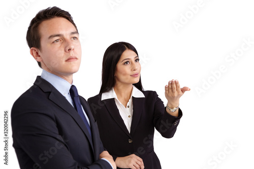 A young business woman is showing a hand gesture while a young business man looks ahead. He is unconvinced.