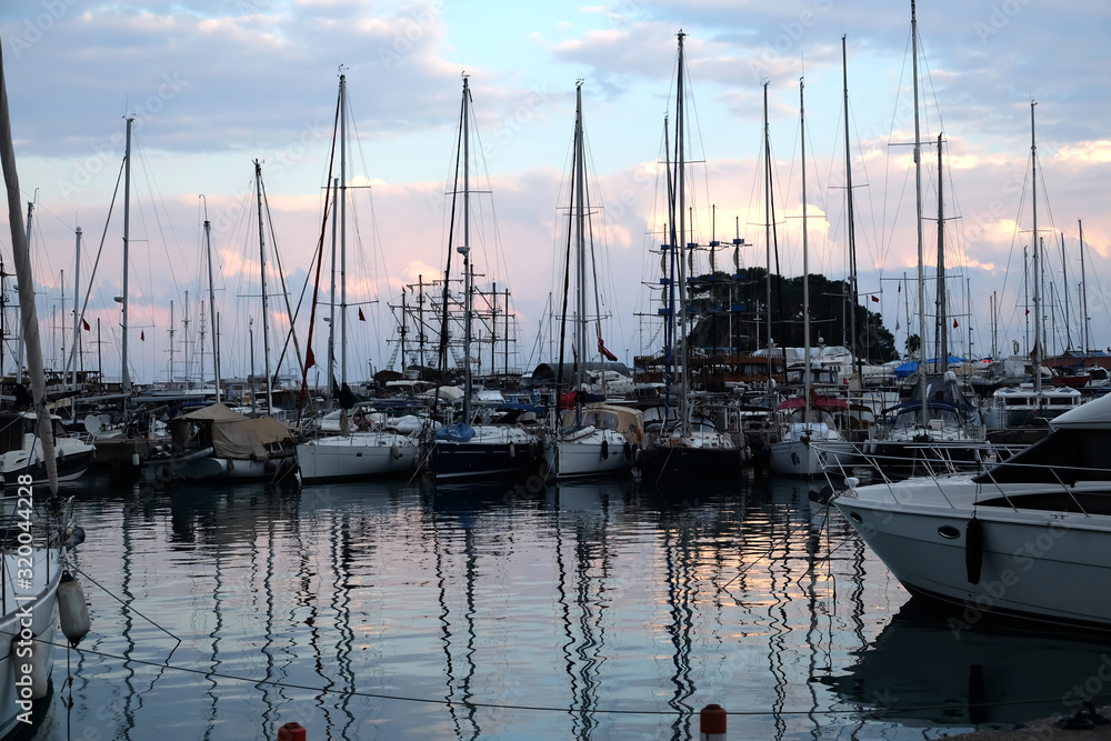Marine with many different sea yacht parking in calm water in the evening with reflection in water surface