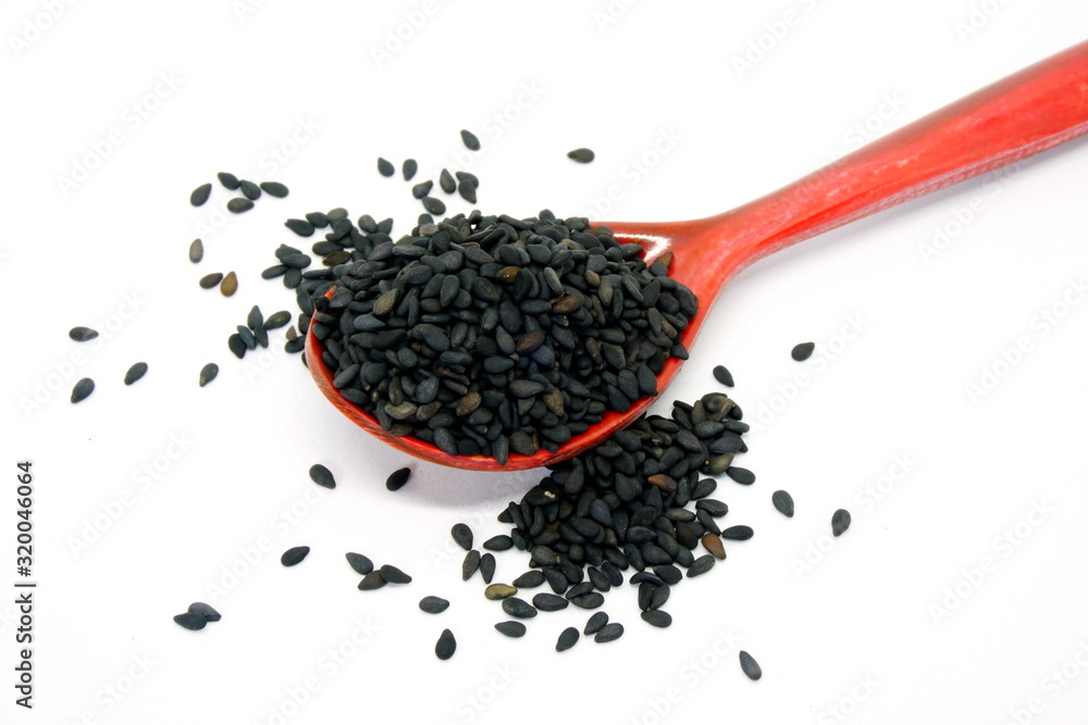Black sesame seeds in a brown wooden spoon Black sesame seeds in a brown wooden spoon