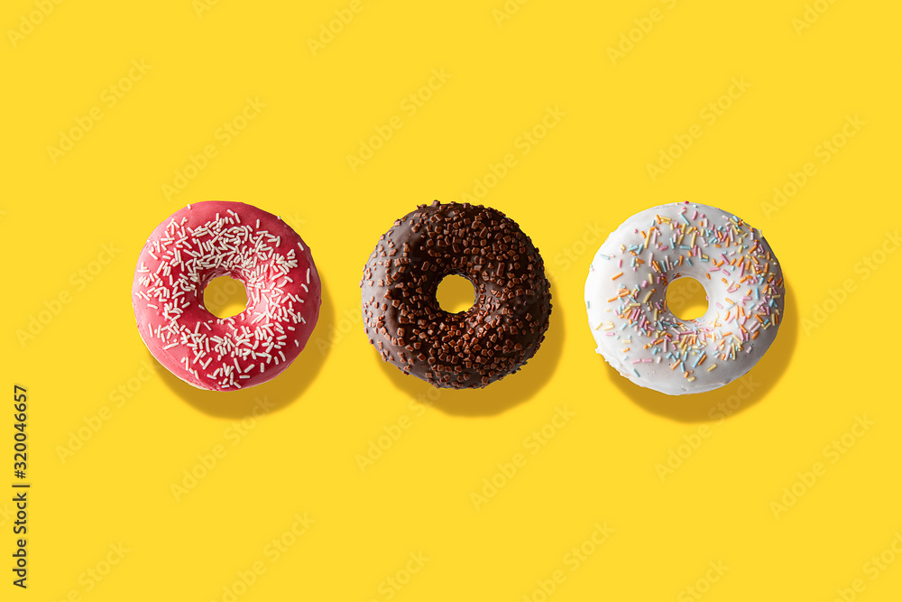 three different donuts on a yellow background three different donuts on a yellow background