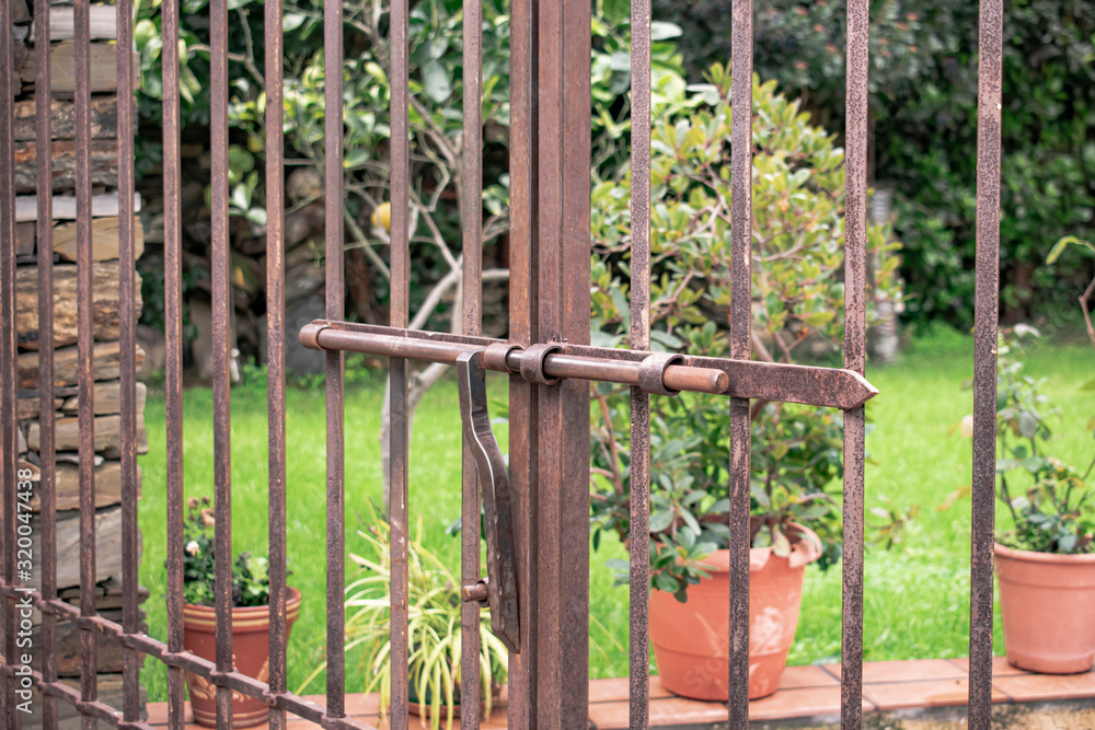 Metal gate with sliding bar to block access to a garden Metal gate with sliding bar to block access to a garden