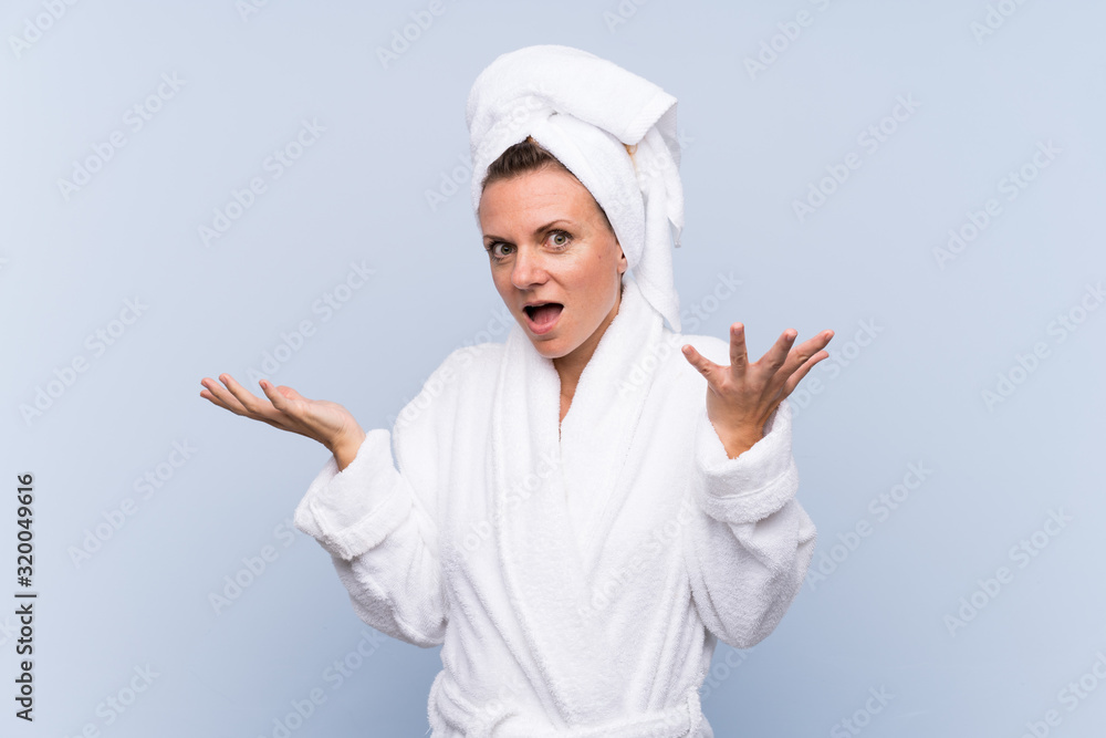Woman in bathrobe over isolated blue background unhappy and frustrated with something Woman in bathrobe over isolated blue background unhappy and frustrated with something