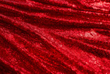 bright red fabric with small round sequins, with metallic sheen laid out by waves for Valentine's day