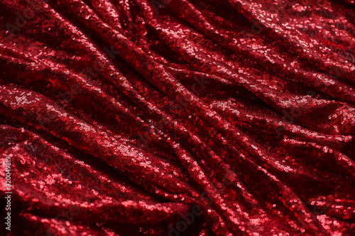 bright red fabric with small round sequins, with metallic sheen laid out by waves for Valentine's day