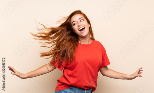 Teenager redhead girl dancing over isolated background