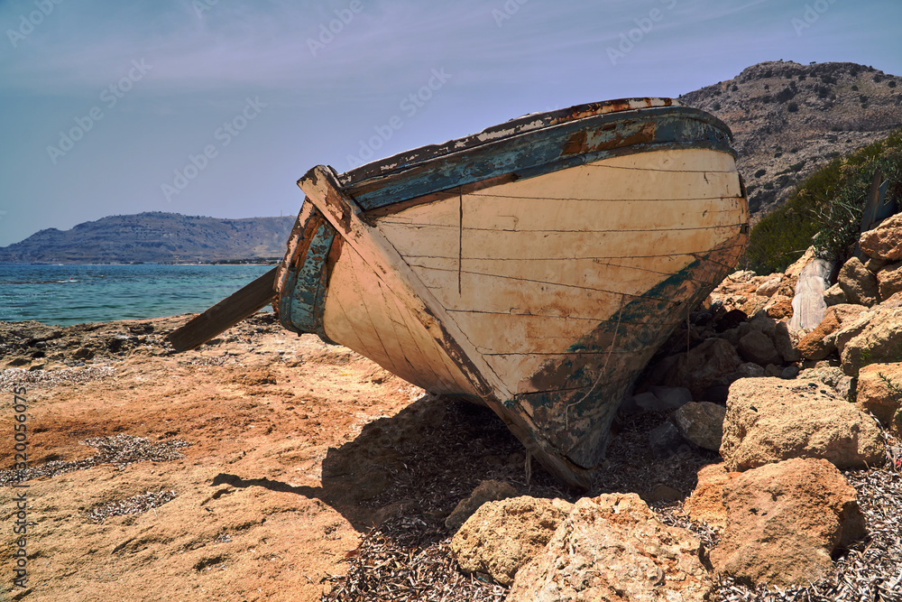 A dilapidated wooden boat on the seafront on the Greek island of Rhodes. A dilapidated wooden boat on the seafront on the Greek island of Rhodes.