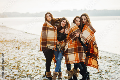 young and stylish four girls have fun in a winter park