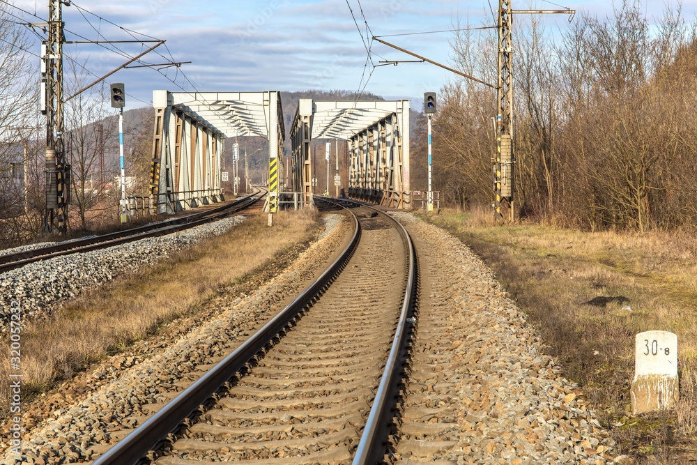 Metal railway bridge over the Svratka River near the town of Tisnov in the Czech Republic - EU. Transport on rails. Railway transport infrastructure. Metal railway bridge over the Svratka River near the town of Tisnov in the Czech Republic - EU. Transport on rails. Railway transport infrastructure.