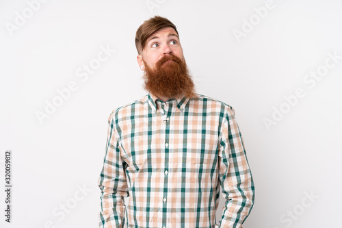 Redhead man with long beard over isolated white background and looking up