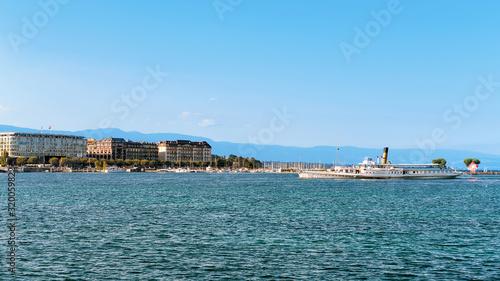 Steamer at Geneva Lake seen from the embankment of Promenade du Lac in summer, Geneva, Switzerland. People on the background