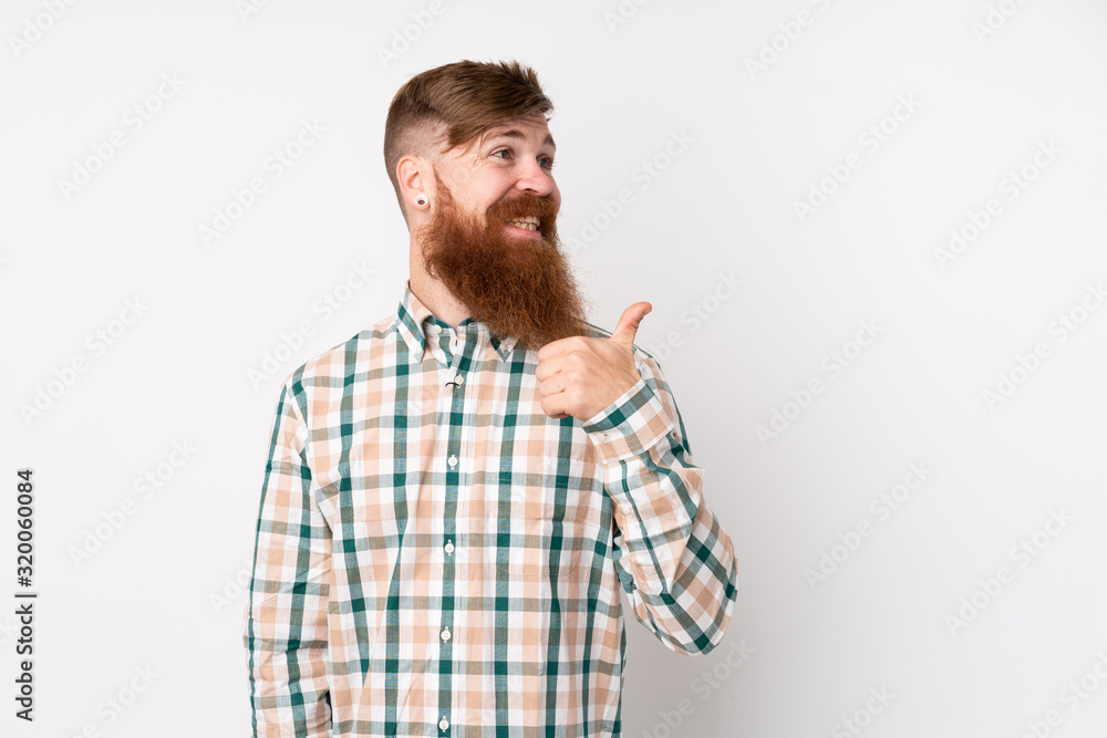 Redhead man with long beard over isolated white background pointing to the side to present a product Redhead man with long beard over isolated white background pointing to the side to present a product