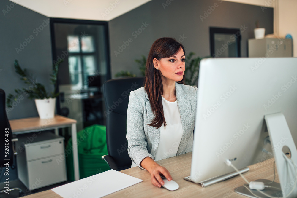 Beautiful manager working on computer in modern office. Beautiful manager working on computer in modern office.
