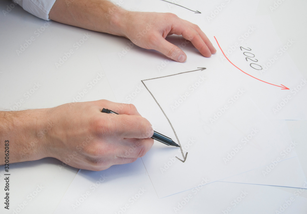 Hands of a male businessman write on a white sheet a growth graph. Growth arrow. On white background Hands of a male businessman write on a white sheet a growth graph. Growth arrow. On white background