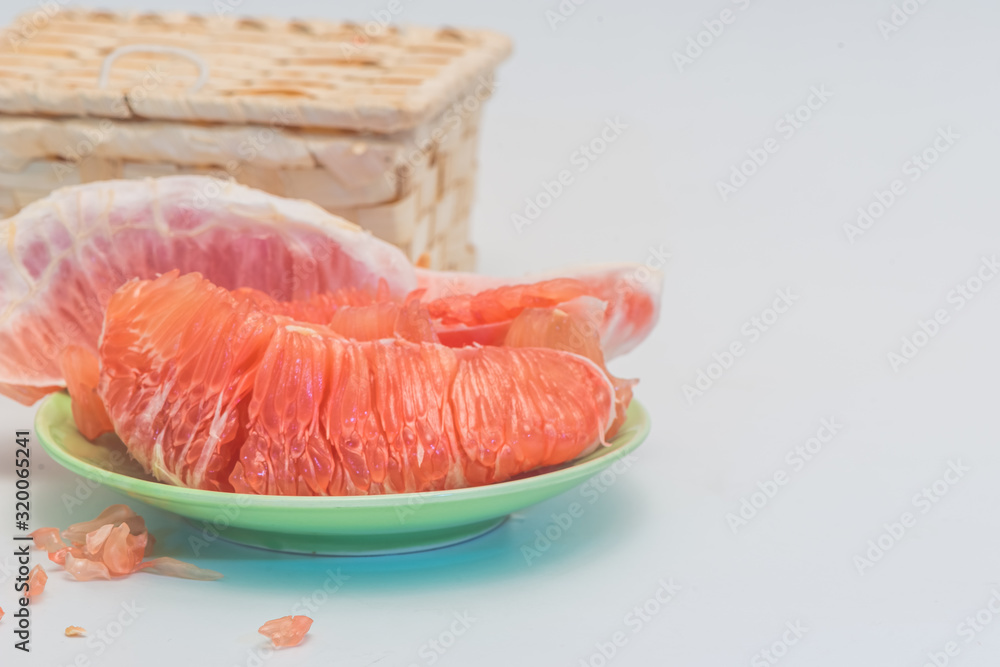The red flesh of the red flesh pomelo and a basket are isolated on a white background. The red flesh of the red flesh pomelo and a basket are isolated on a white background.