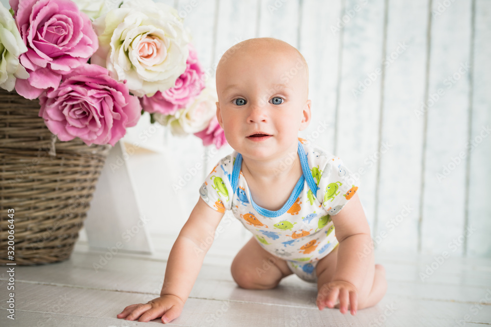 Portrait of a little happy baby crawling on the floor. The concept of a healthy developed child. Preparing for the first steps of the baby Portrait of a little happy baby crawling on the floor. The concept of a healthy developed child. Preparing for the first steps of the baby