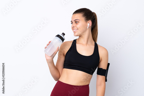 Teenager sport girl over isolated white background with sports water bottle © luismolinero