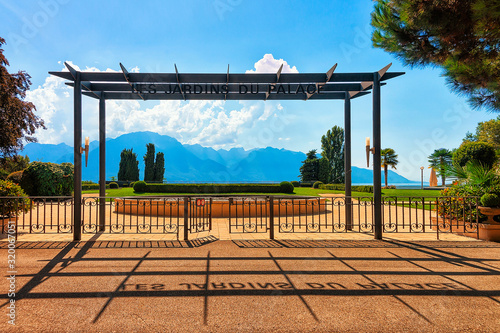 Entrance into garden at Geneva Lake in Montreux, Swiss Riviera. Alps mountains on the background