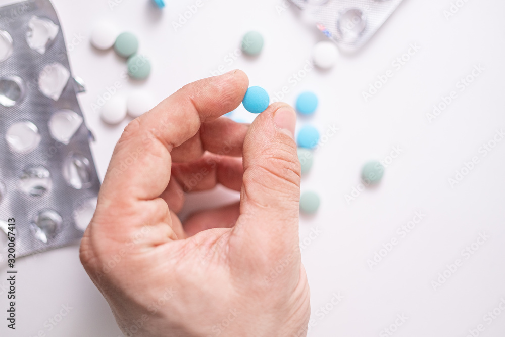 colourful medicine pills with hand. Coronavirus treatment concept