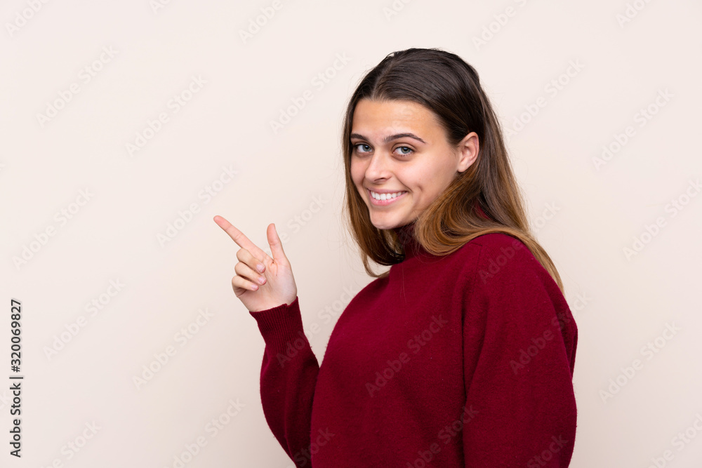Teenager girl over isolated background pointing finger to the side Teenager girl over isolated background pointing finger to the side