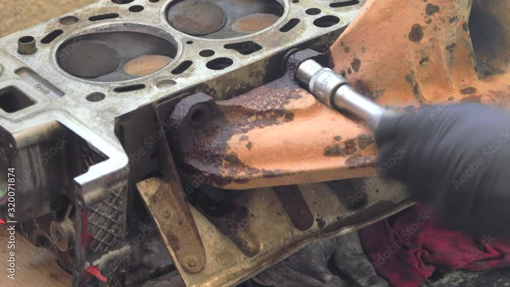 Car engine repair DIY. Auto mechanic disassemble cylinder head. Close up unscrews the bolts and