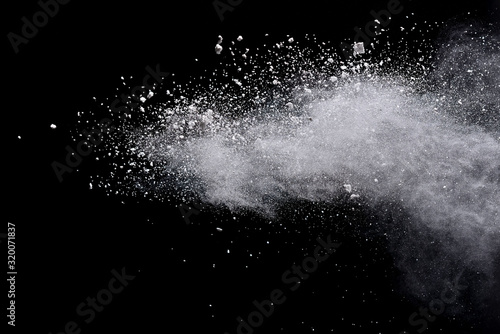 Freeze motion of white color powder exploding on dark background. 