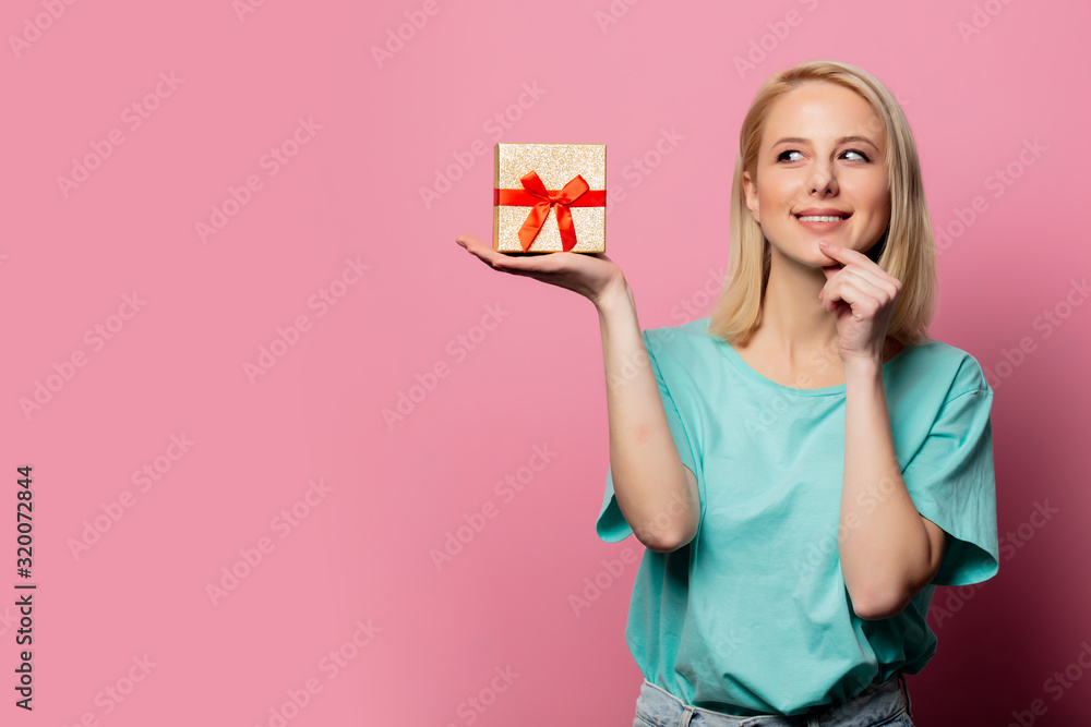 Beautiful smiling woman with gift box on pink background Beautiful smiling woman with gift box on pink background