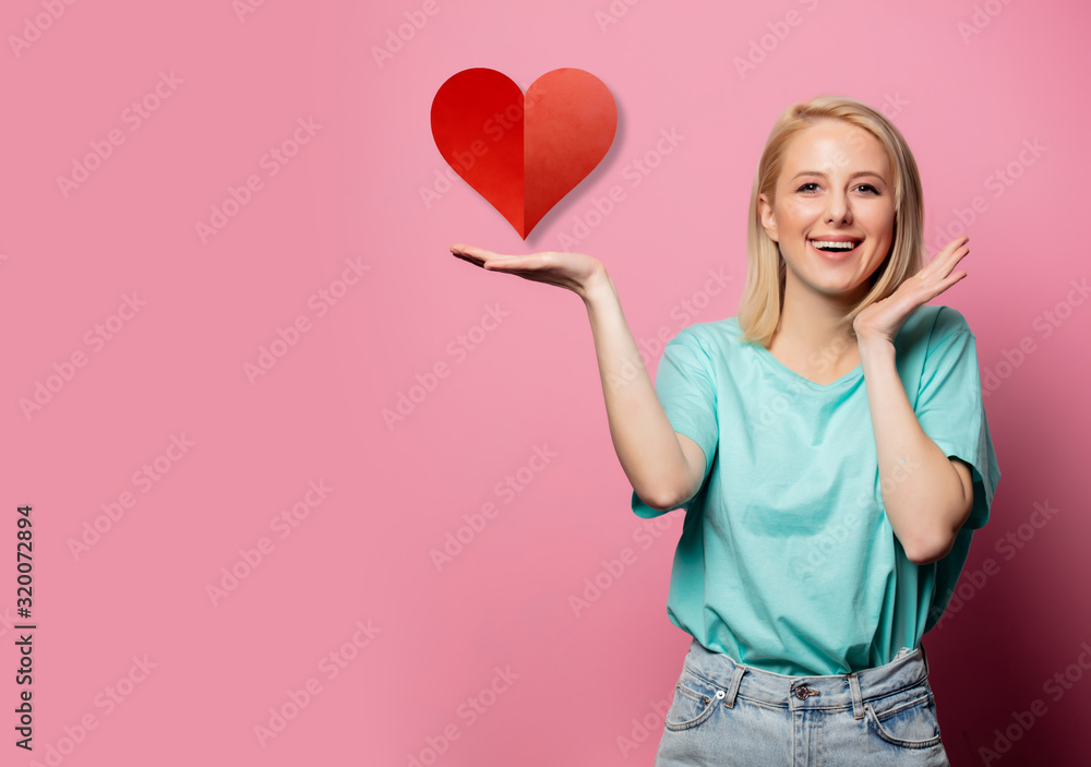 Beautiful smiling woman with heart shape sign on pink background Beautiful smiling woman with heart shape sign on pink background