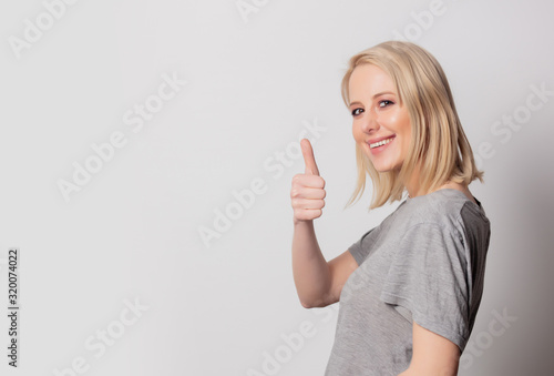 Beautiful blonde woman show OK gesture on white background