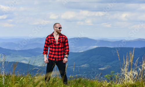 power of nature. man on mountain landscape. camping and hiking. sexy macho man in checkered shirt. countryside concept. farmer on rancho. cowboy in hat outdoor. travelling adventure. hipster fashion