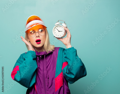 Beautiful woman in 90s sport suit with alarm clock