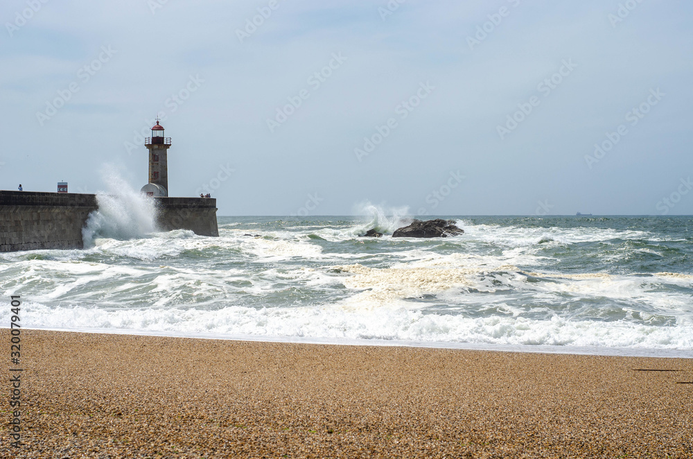 Lighthouse on a Porto city Portugal beach with dramatic waves of atlantic ocean